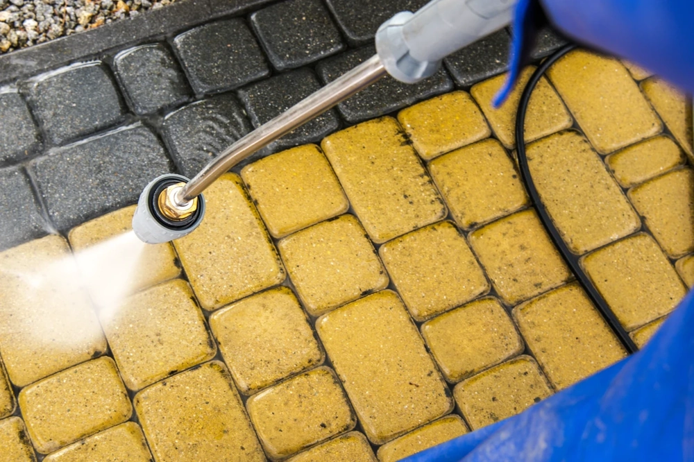 Hochdruckreinigung gelber Pflastersteine auf Gartenweg – Pflasterreinigung