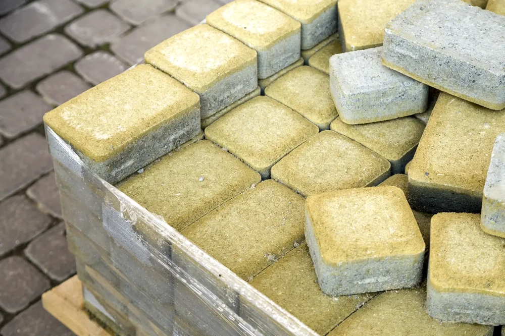 Gestapelte Betonpflastersteine auf Palette für Pflasterarbeiten im Außenbereich